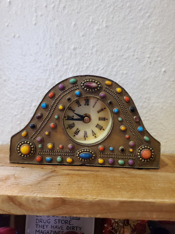 This is a hard resin with faux jewels. Battery operated clock